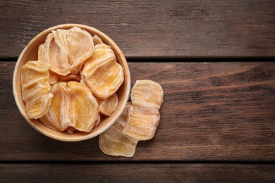 Photo of Delicious dried jackfruit slices on wooden table, flat lay. Space for text