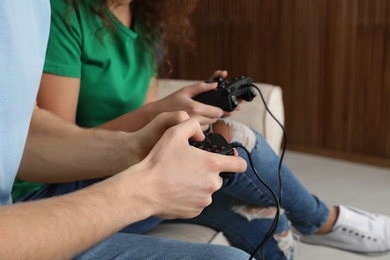 Young couple playing video games at home, closeup