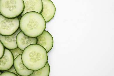 Fresh slices of cucumbers on white background, top view. Space for text