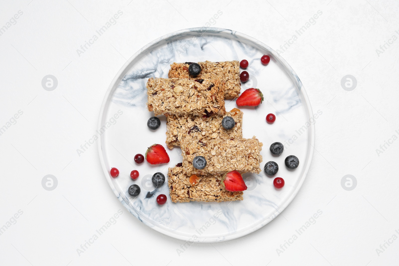 Photo of Tasty granola bars and berries on white background, top view