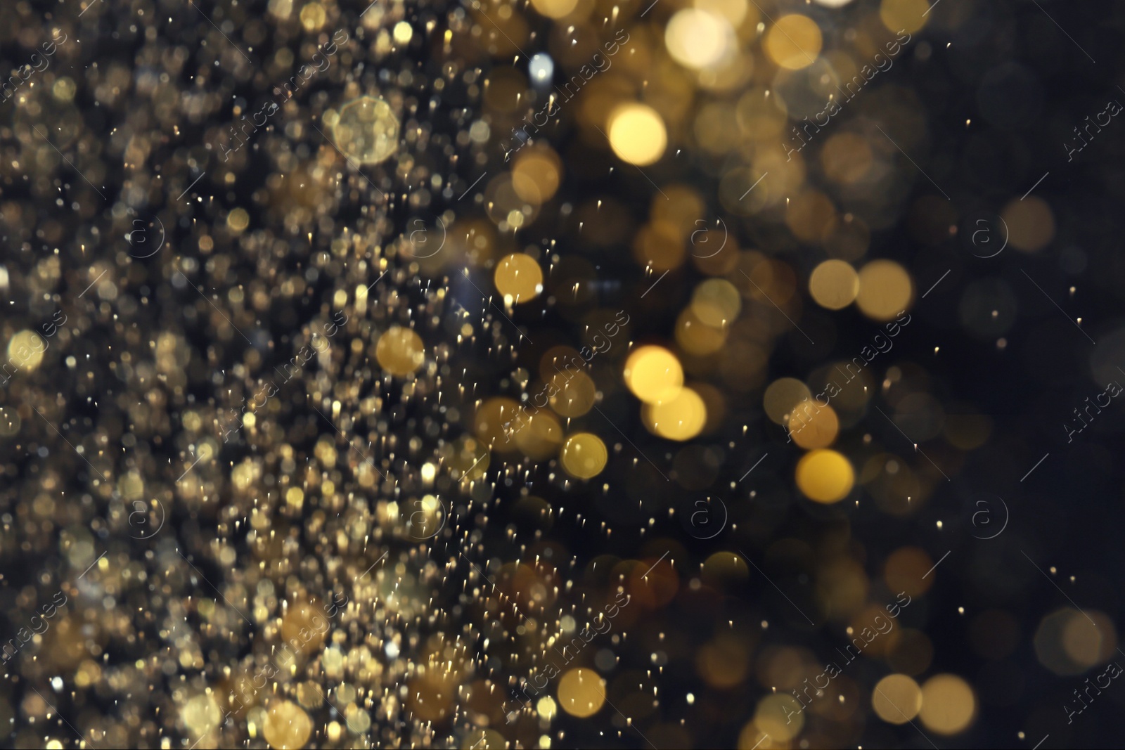 Photo of Blurred view of golden lights on black background. Bokeh effect