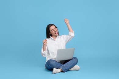 Photo of Happy young woman with laptop on light blue background