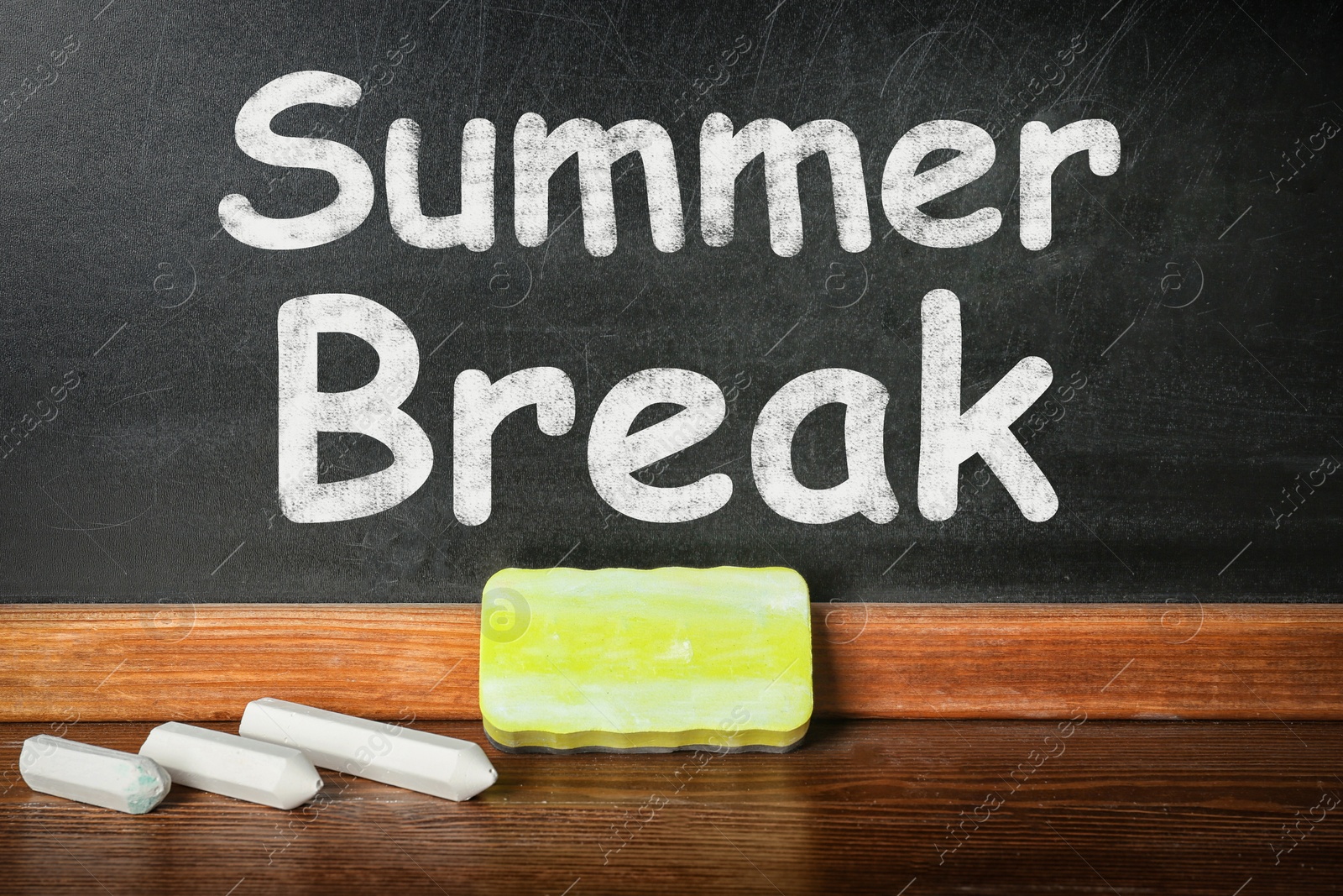 Image of Chalk and duster on table near blackboard with inscription Summer Break. School holidays 