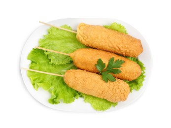 Photo of Delicious deep fried corn dogs with lettuce and parsley on white background, top view