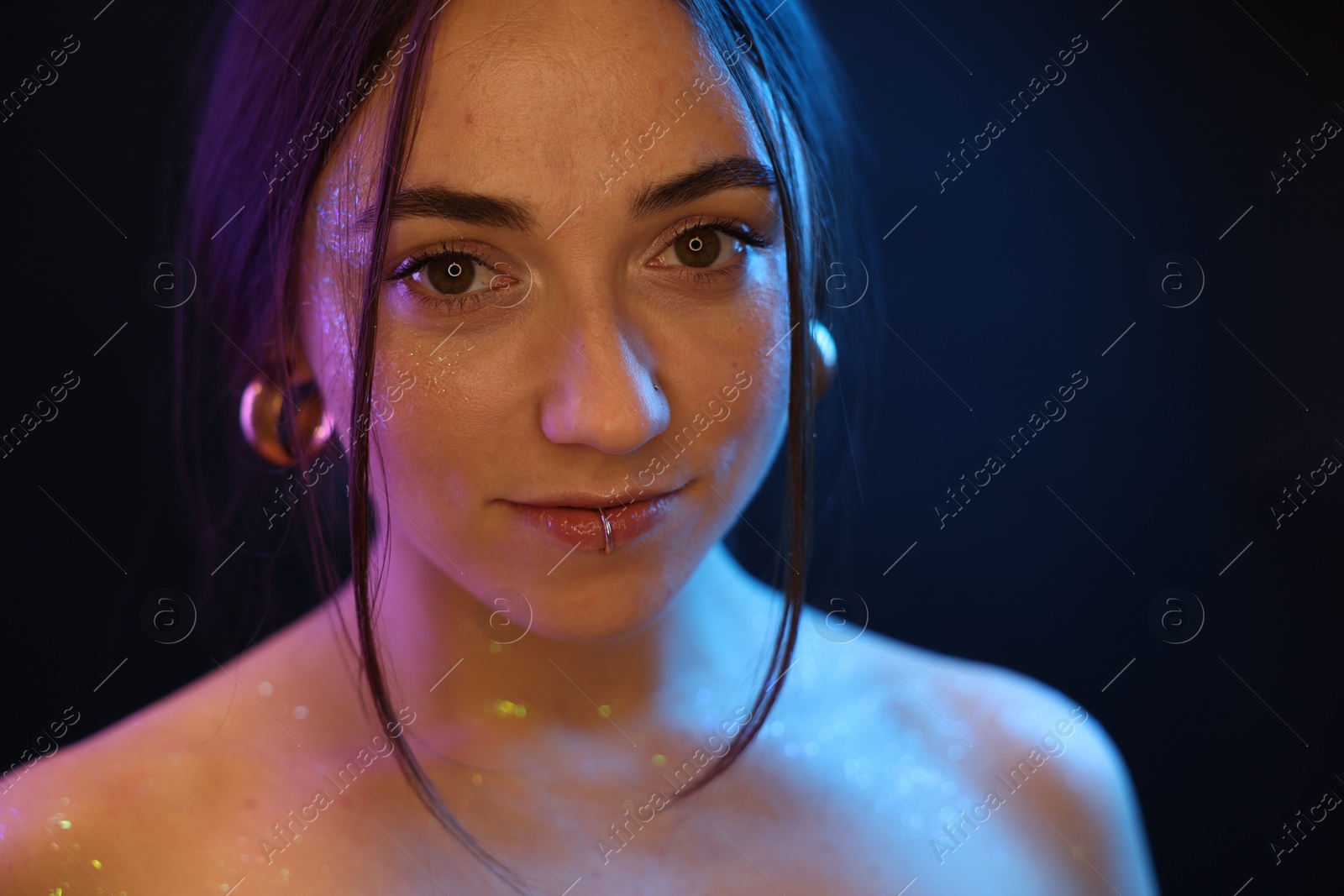 Photo of Portrait of beautiful woman on dark background in neon lights