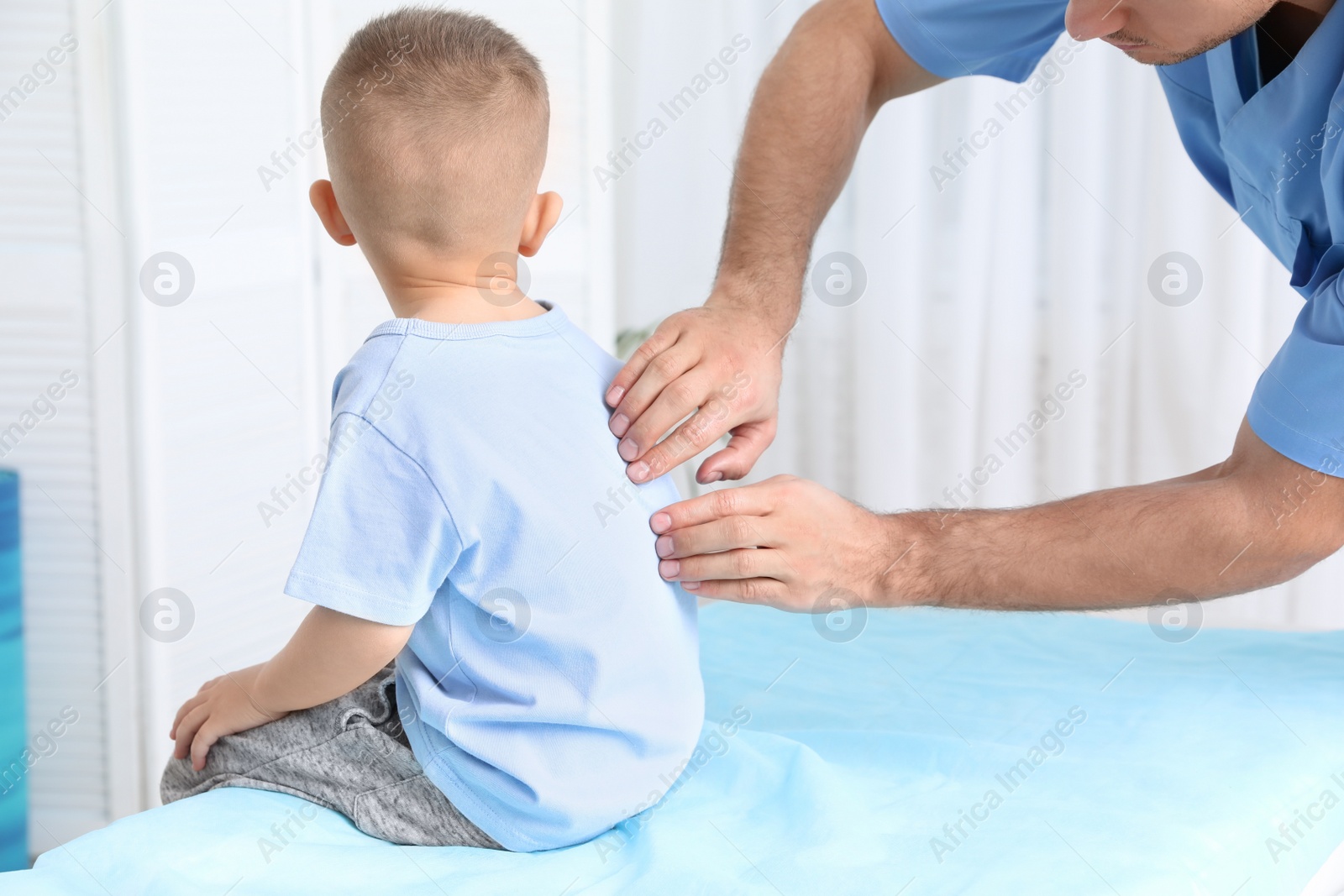 Photo of Orthopedist examining child's back in clinic, closeup. Scoliosis treatment