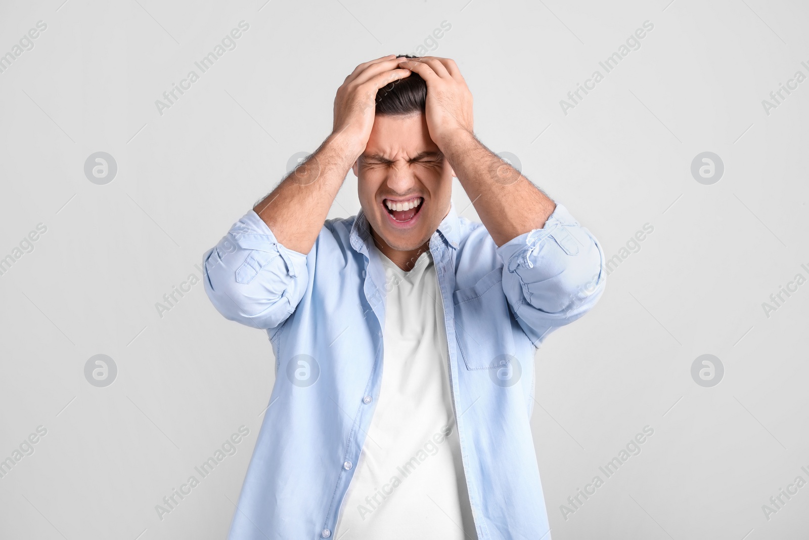 Photo of Portrait of stressed man on light background