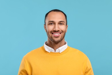 Photo of Portrait of smiling man with healthy clean teeth on light blue background