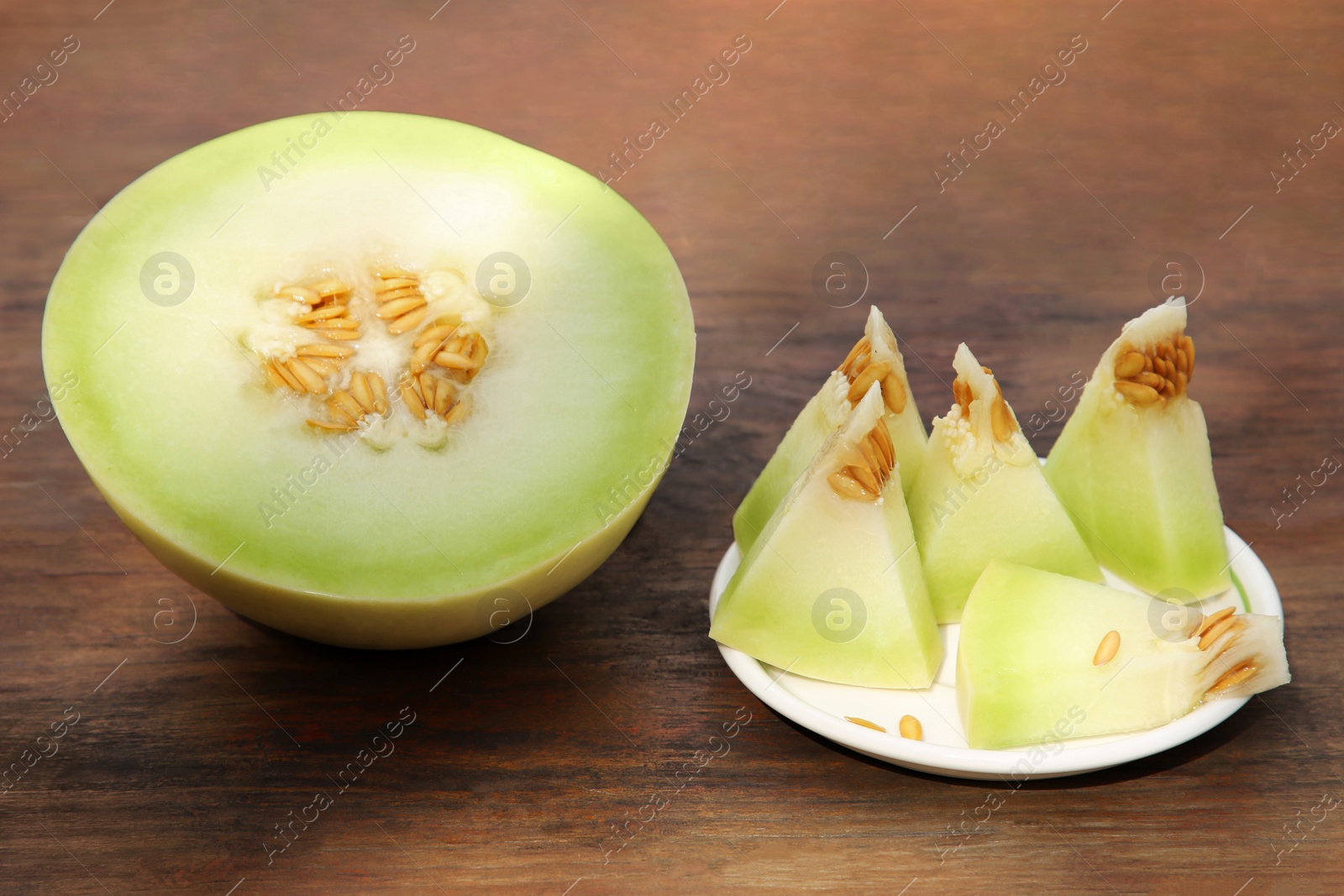 Photo of Cut tasty ripe melon on wooden table