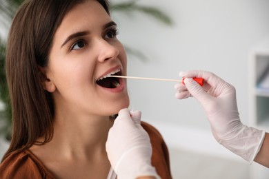 Doctor taking sample for DNA test from woman in clinic