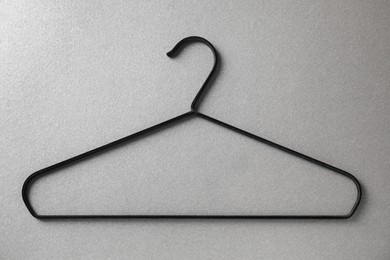 One black hanger on grey background, top view