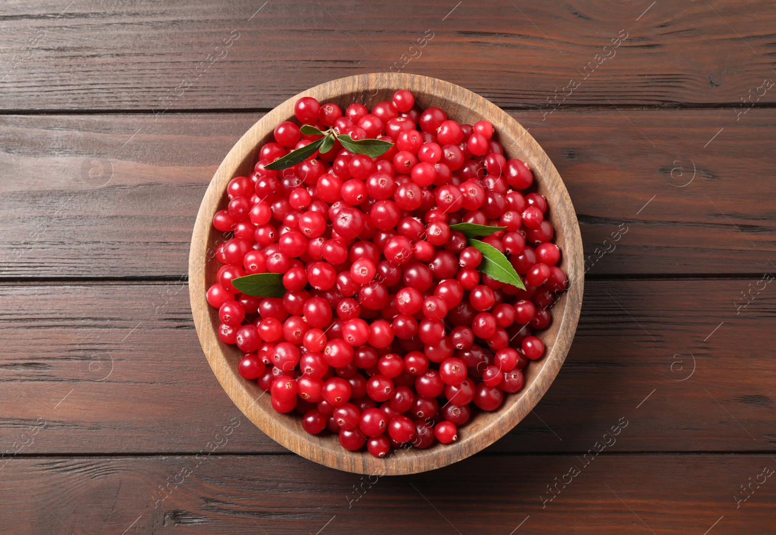 Photo of Tasty ripe cranberries on brown wooden table, top view