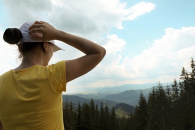 Photo of Female hiker viewing mountain landscape. Space for text