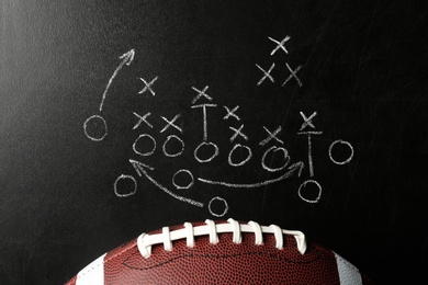 Photo of Chalkboard with football game scheme and rugby ball, top view