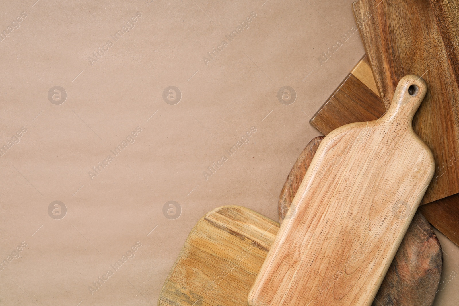 Photo of Set of different wooden boards on brown background, flat lay with space for text. Cooking utensils