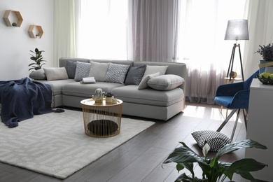 Photo of Elegant living room with comfortable sofa near windows. Interior design