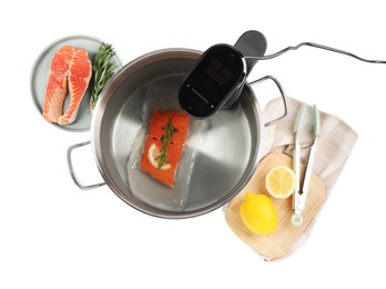 Photo of Thermal immersion circulator and vacuum packed salmon in pot on white background, top view. Sous vide cooking
