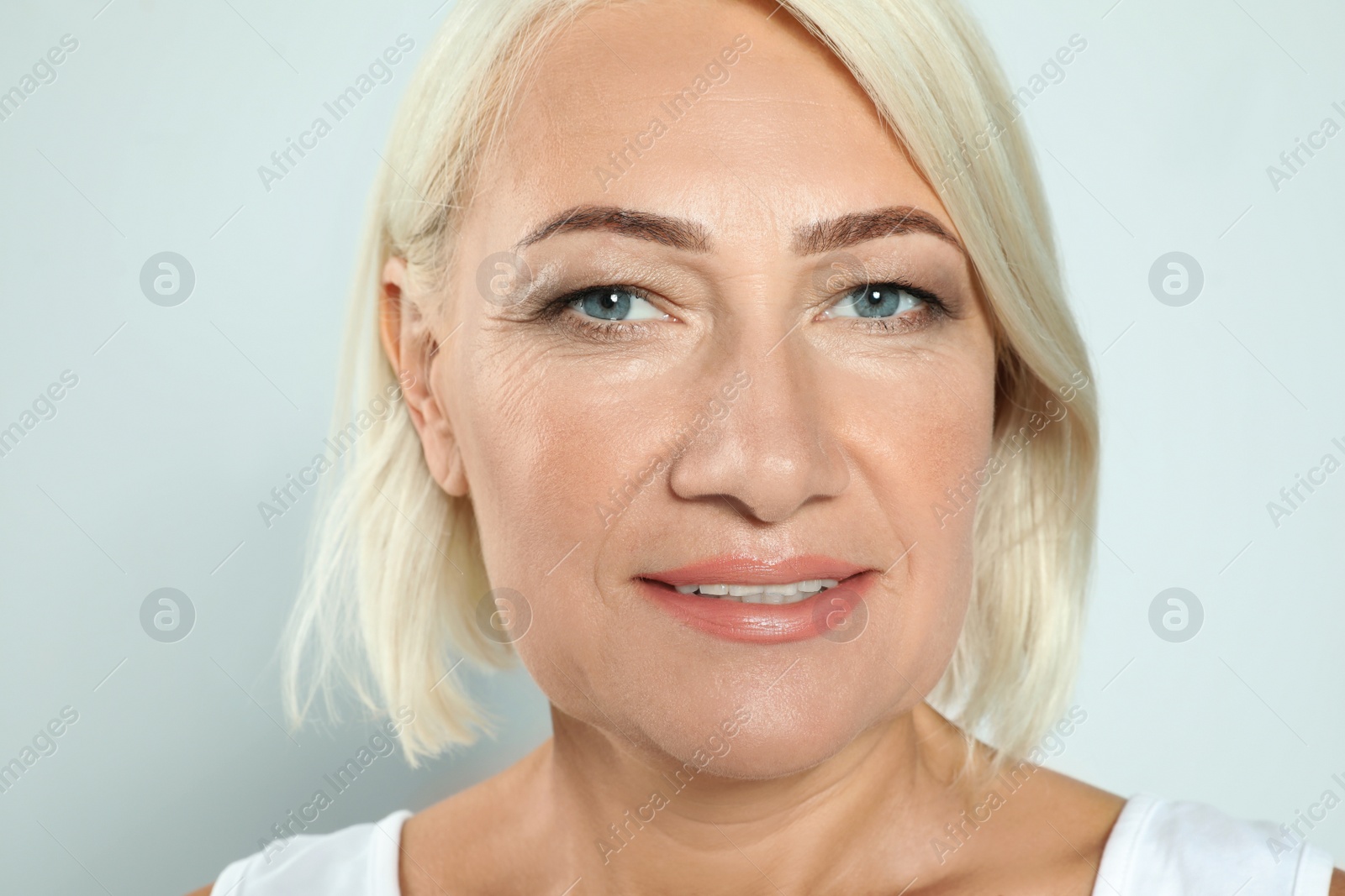 Photo of Portrait of mature woman with beautiful face on grey background