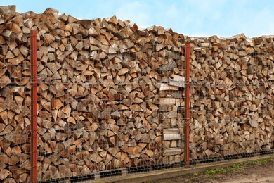 Photo of Stacked firewood outdoors. Heating house in winter