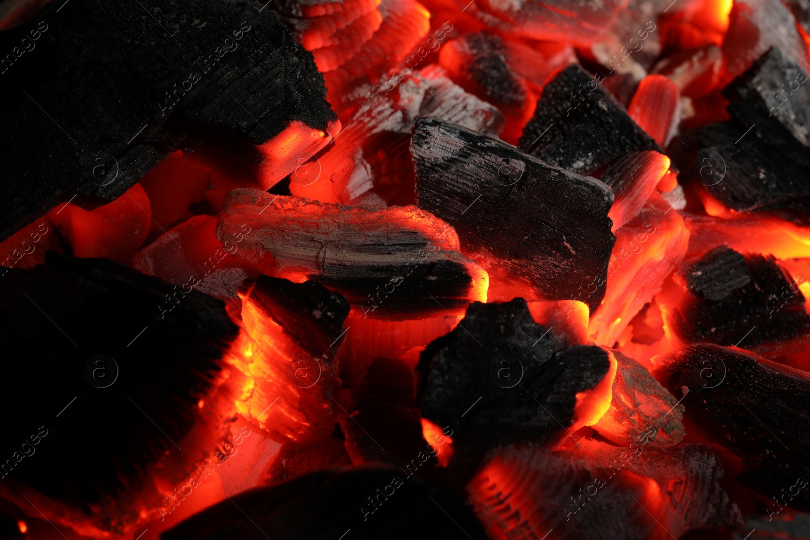 Photo of Pieces of hot smoldering coal as background, closeup