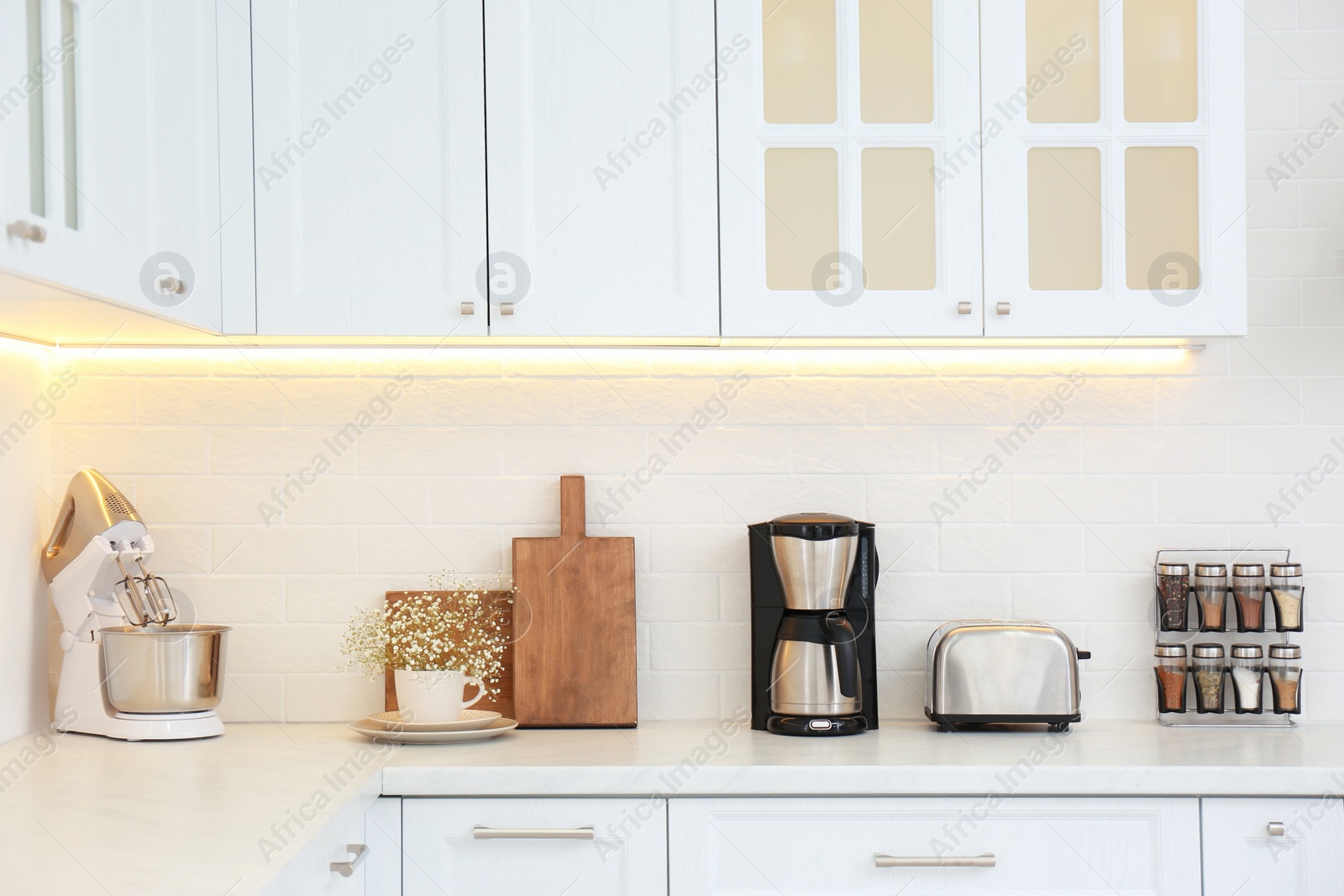 Photo of Modern toaster and household appliances on counter in kitchen