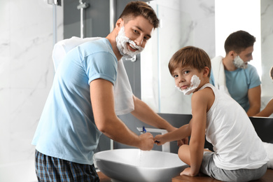 Photo of Dad and son washing razors in bathroom
