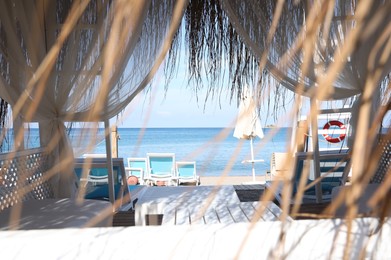 Photo of Comfortable hut and loungers on sea beach at resort