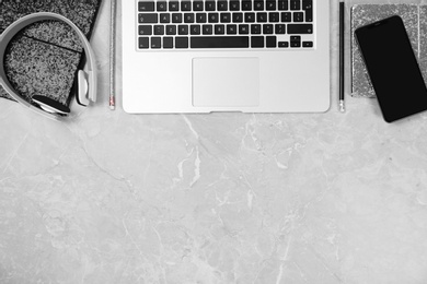 Flat lay composition with laptop and phone on grey marble table, space for text. Designer's workplace