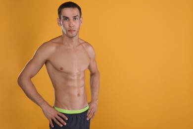Photo of Handsome shirtless man with slim body on yellow background. Space for text