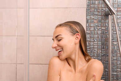 Photo of Beautiful young woman taking shower at home