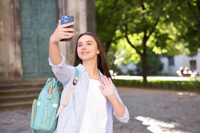 Photo of Beautiful travel blogger with smartphone streaming outdoors