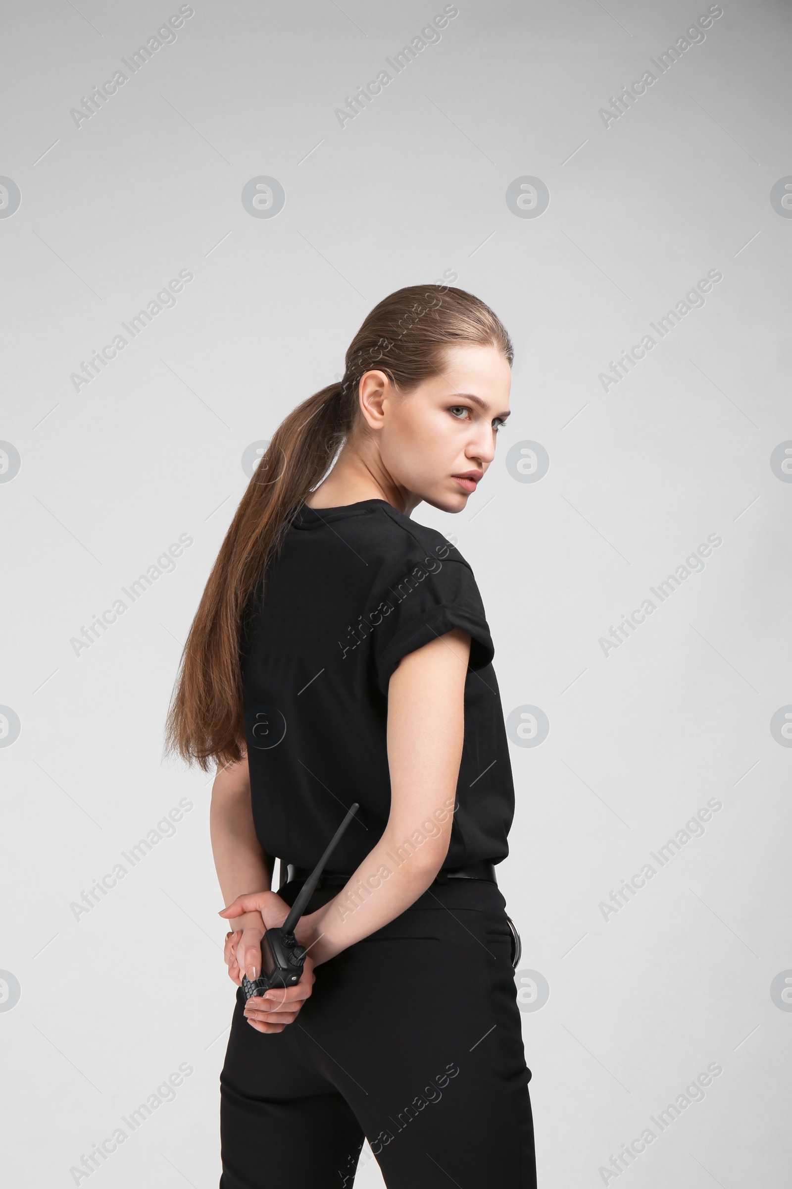 Photo of Female security guard with portable radio transmitter on color background