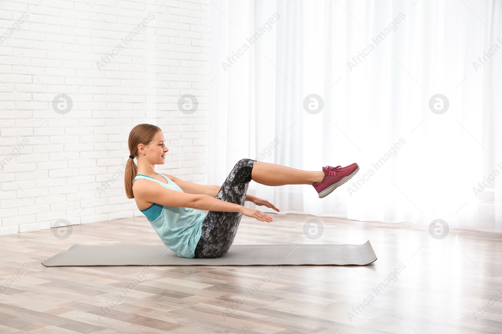 Photo of Young woman doing fitness exercises at home