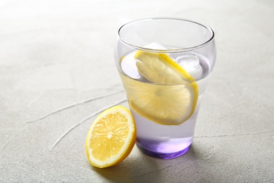 Glass with lemon water on table