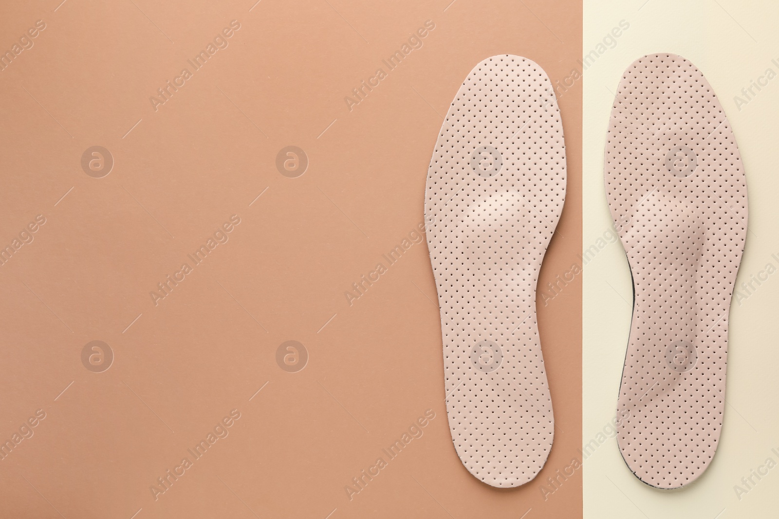 Photo of Orthopedic insoles on color background, flat lay. Space for text