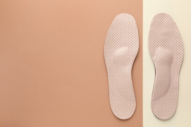 Photo of Orthopedic insoles on color background, flat lay. Space for text