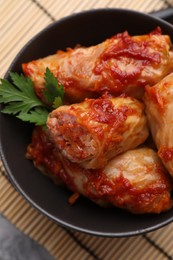 Photo of Delicious stuffed cabbage rolls cooked with tomato sauce on table, top view