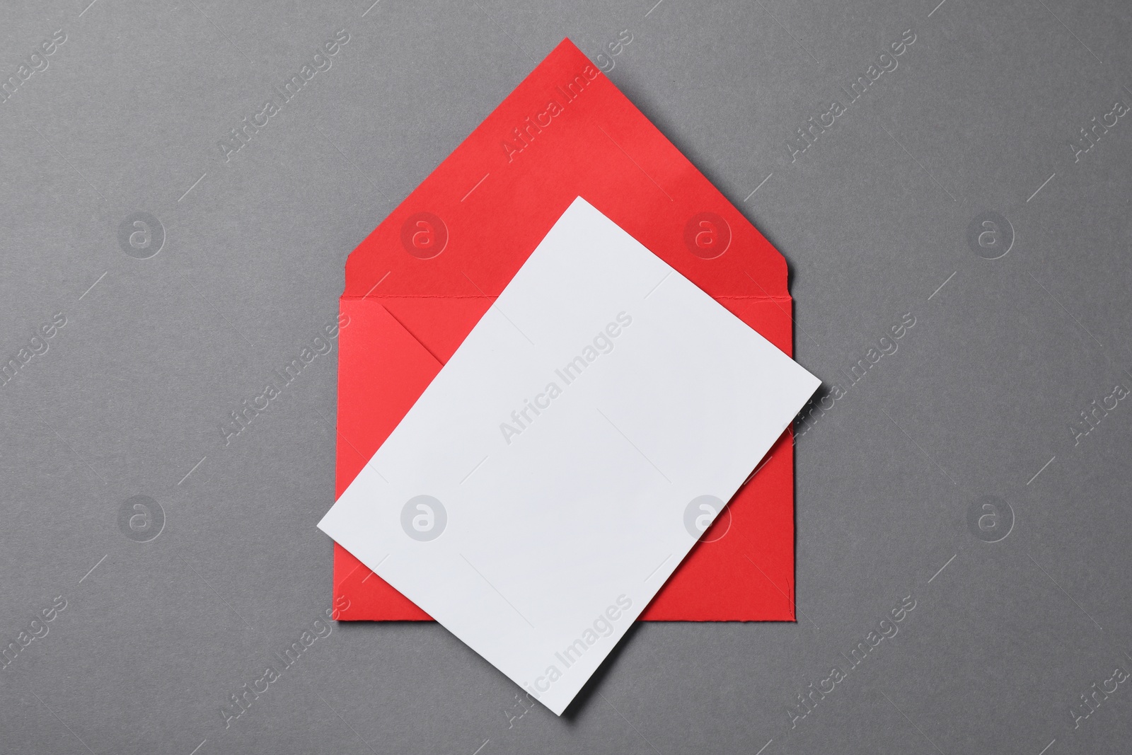 Photo of Blank sheet of paper and letter envelope on grey background, top view