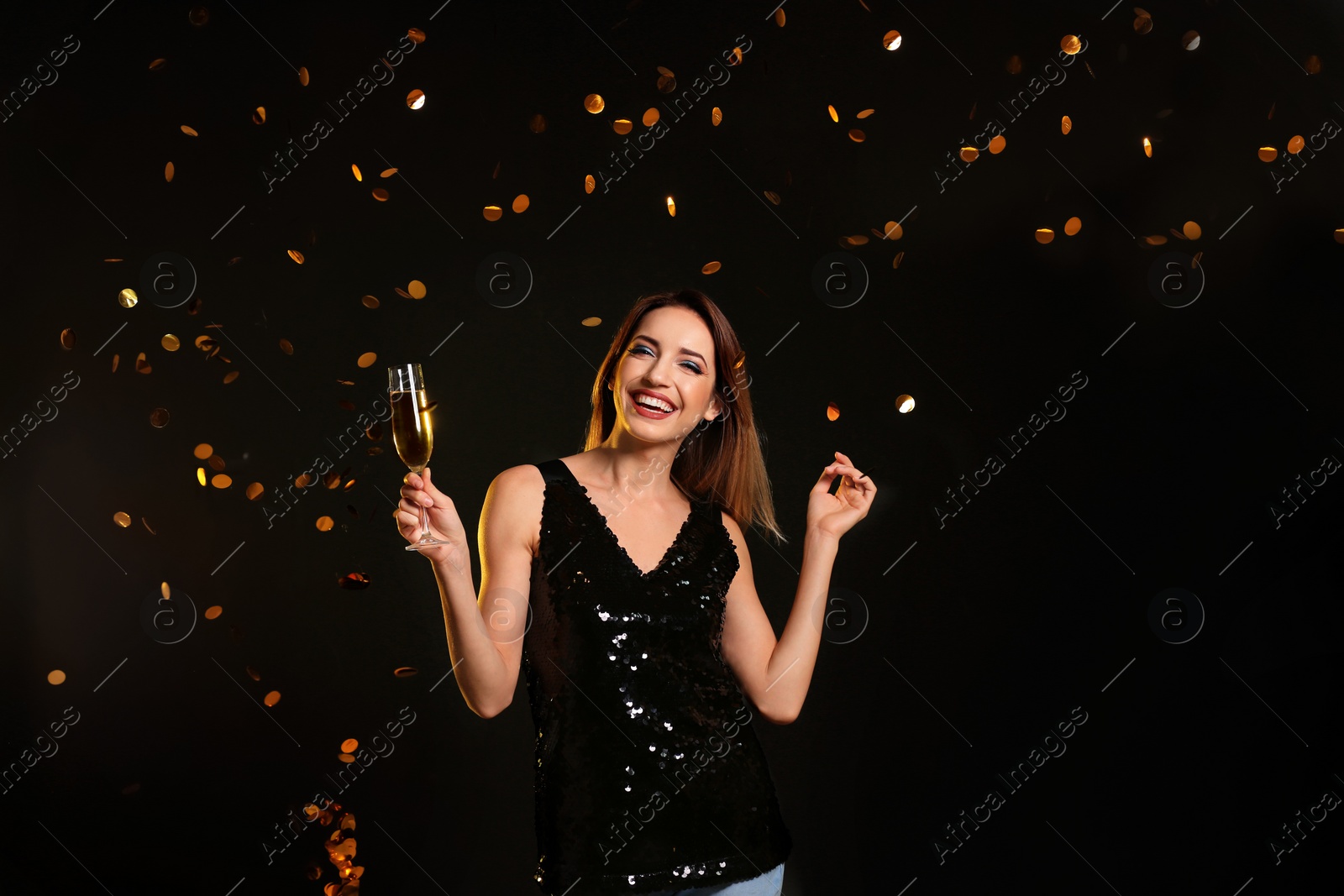 Photo of Portrait of happy woman with champagne in glass and confetti on color background