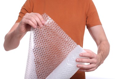 Man holding roll of bubble wrap on white background, closeup. Stress relief