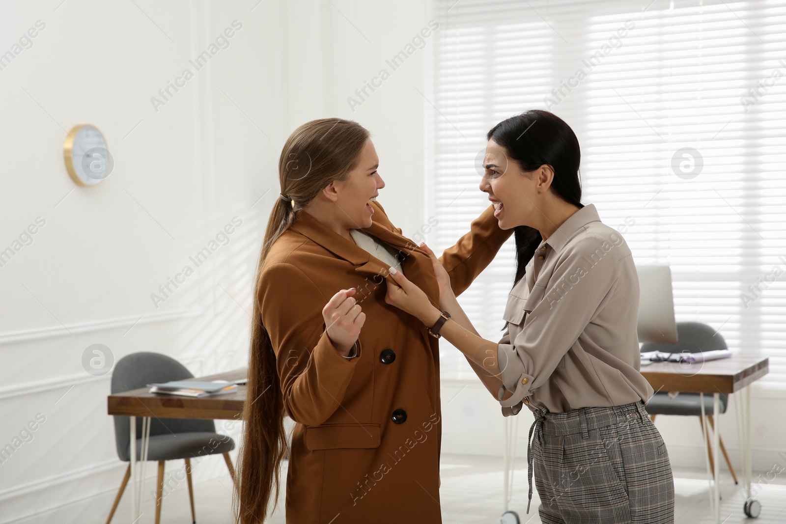 Photo of Emotional colleagues fighting in office. Workplace conflict