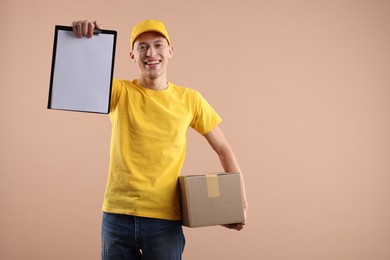 Photo of Happy courier with parcel and clipboard on beige background. Space for text