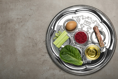 Passover Seder plate (keara) on grey table, top view with space for text. Pesah celebration