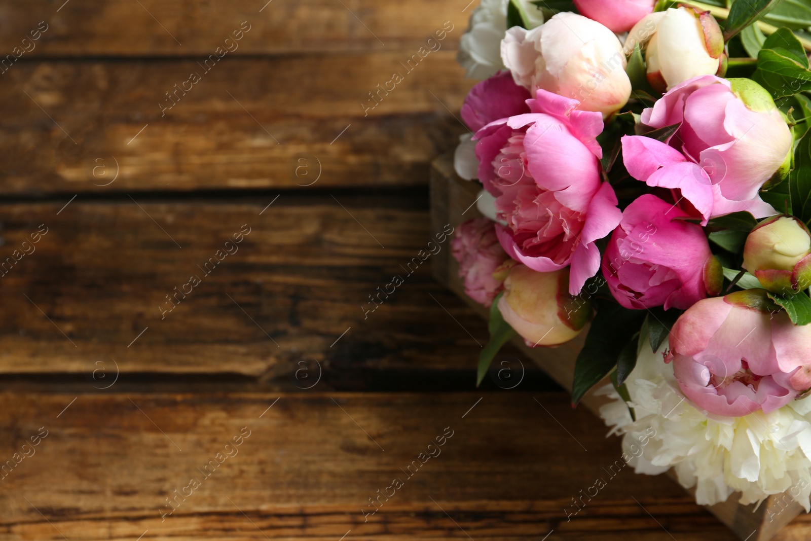 Photo of Bouquet of beautiful peonies on wooden table. Space for text