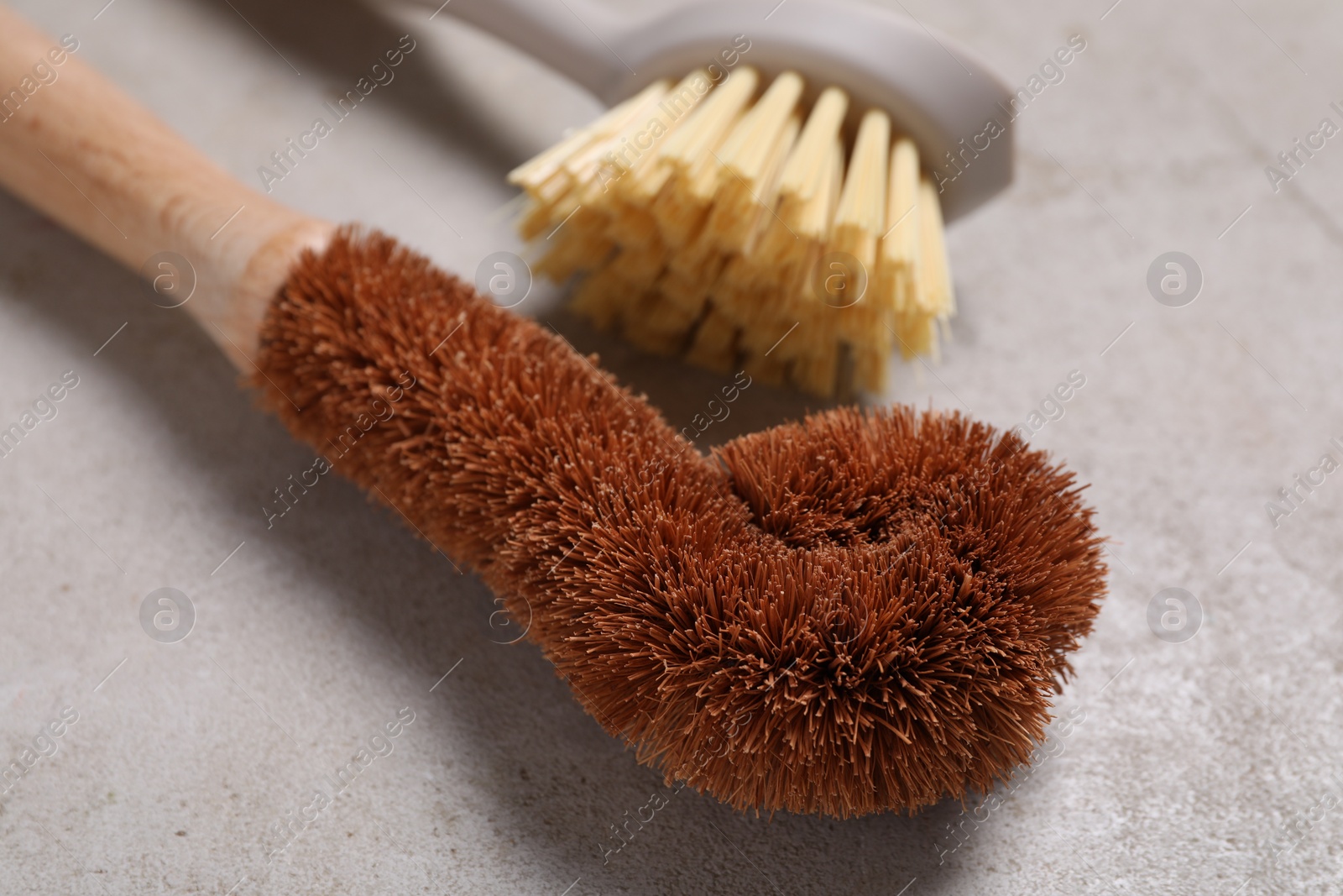 Photo of Cleaning brushes on light grey table, closeup