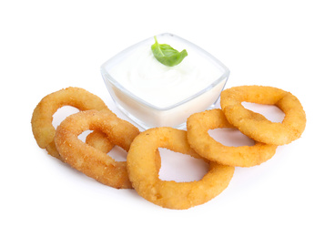 Photo of Delicious onion rings and sauce isolated on white