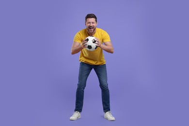 Emotional sports fan with ball on purple background