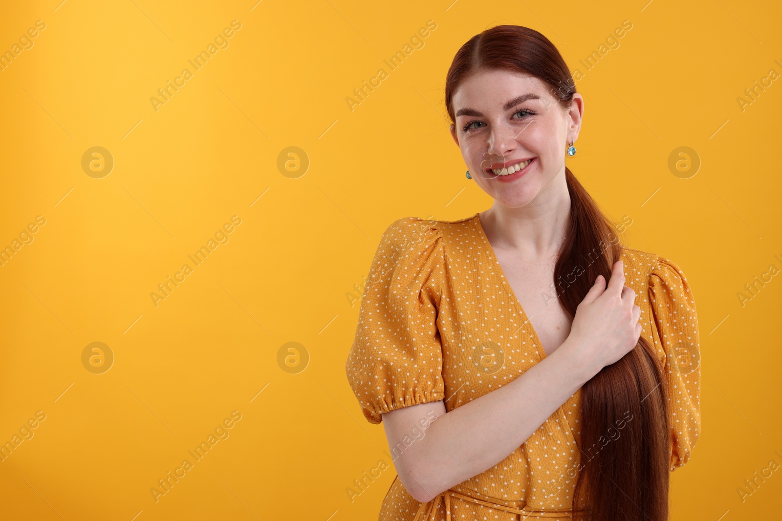 Photo of Portrait of smiling woman on yellow background. Space for text