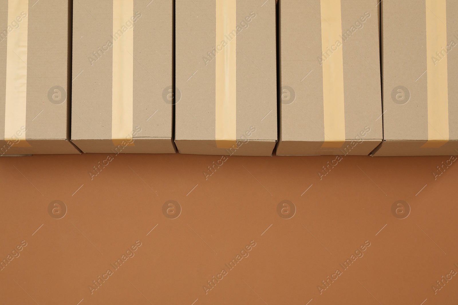 Photo of Cardboard boxes on brown background, flat lay. Space for text