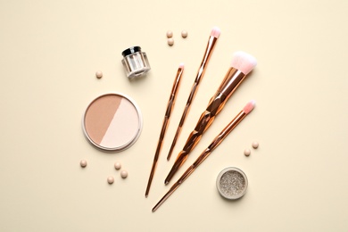 Photo of Flat lay composition with makeup brushes on beige background